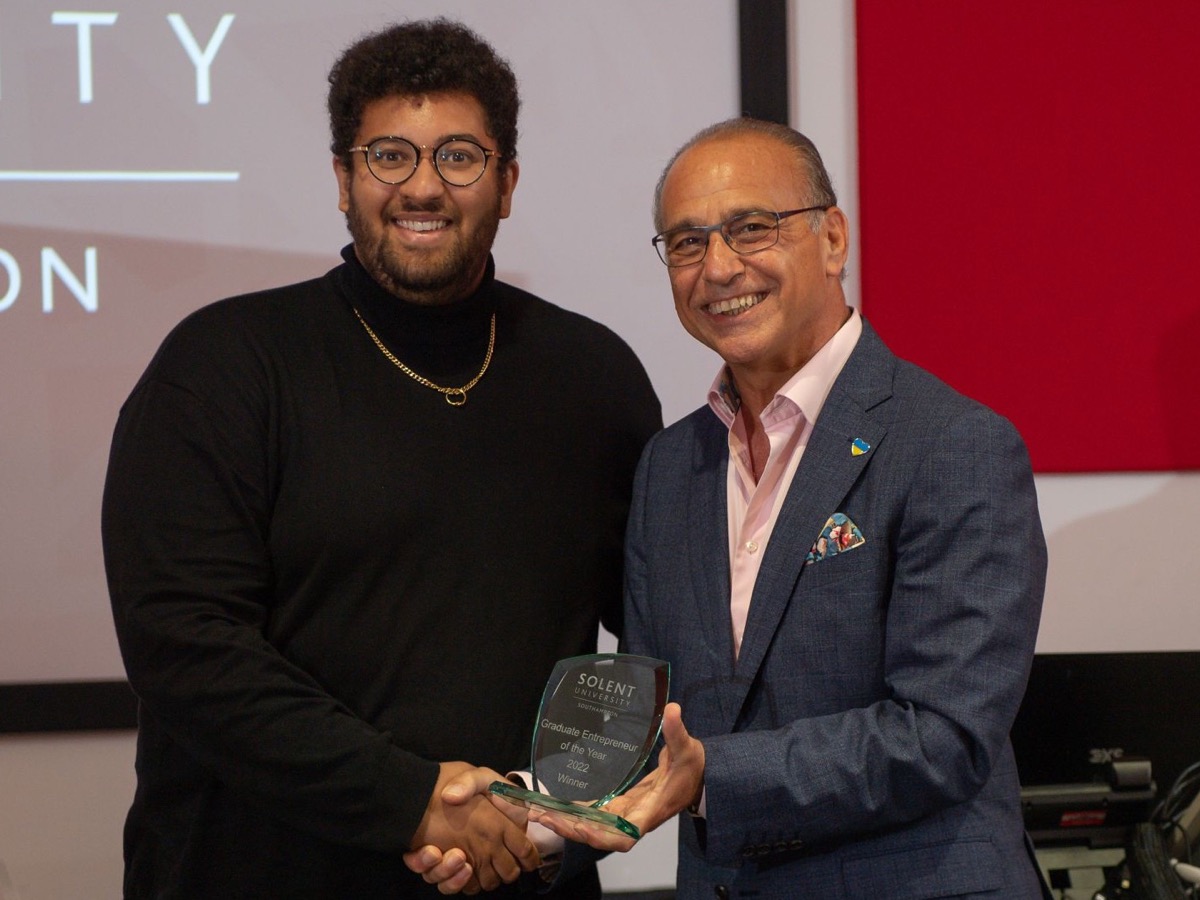 James Gayle and Theo Paphitis holding Solent University's Graduate Entrepreneur of the Year award, 2022.